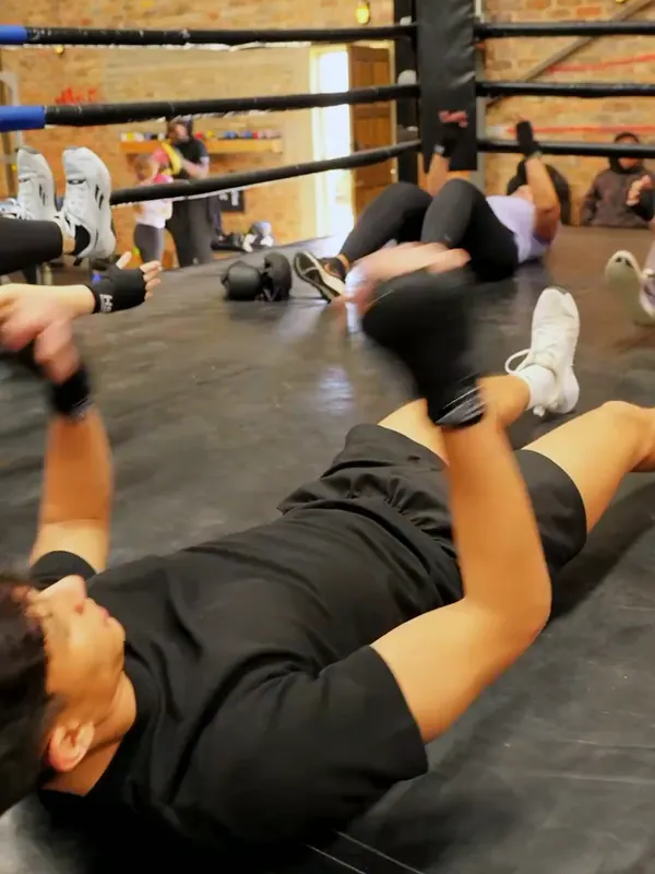 Man doing core work on the mat during a bootcamp session at Urban Warrior Boxing, Sandton